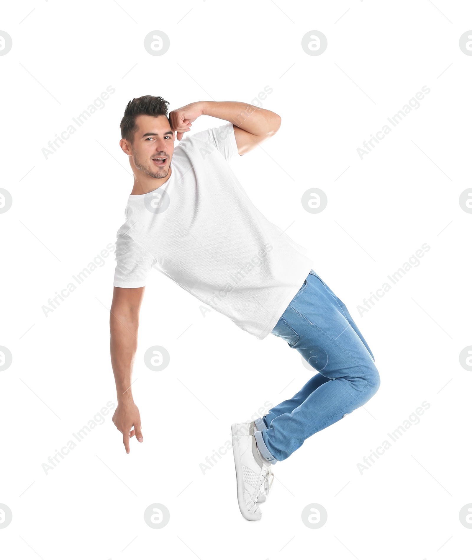 Photo of Young man in stylish jeans jumping on white background