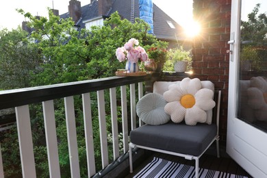 Different plants on railings and chair at cozy balcony outdoors