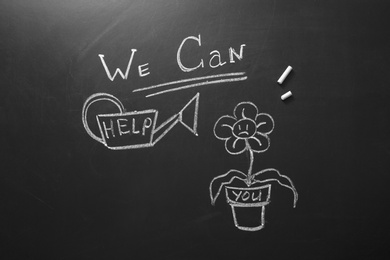 Drawing of flower, watering can and phrase "We can help" on chalkboard, top view