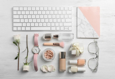 Photo of Flat lay composition with beautiful roses, cosmetics and keyboard on wooden background