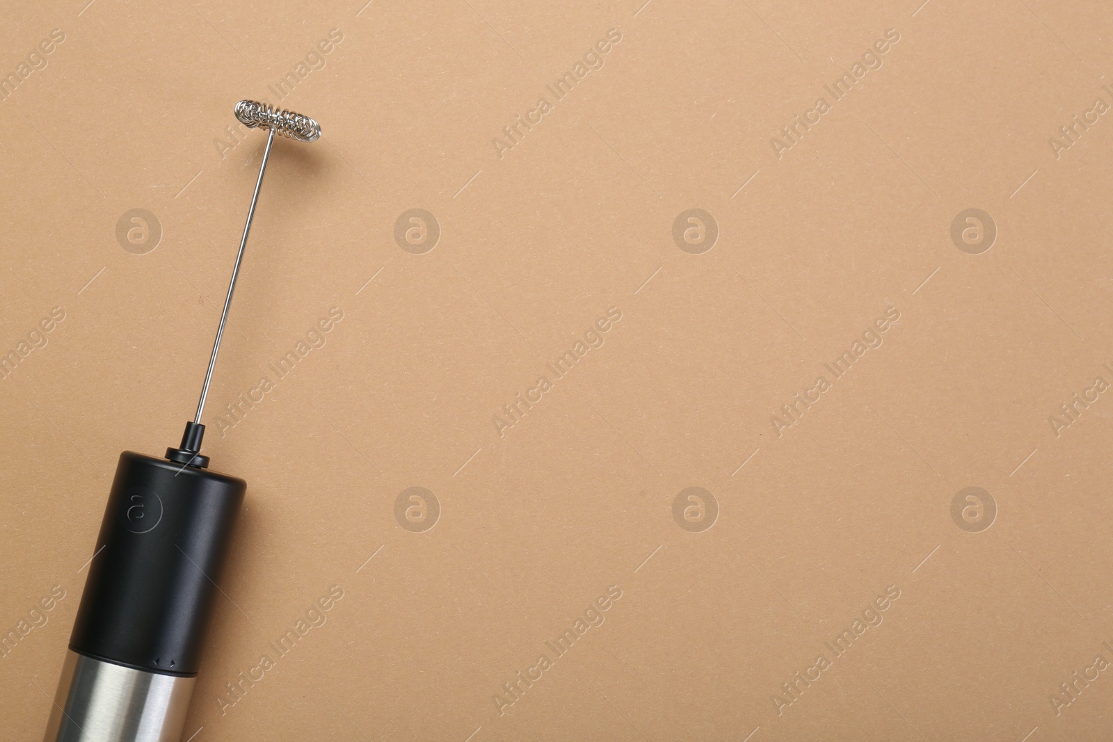 Photo of Milk frother wand on light brown background, top view. Space for text