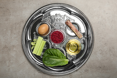Photo of Passover Seder plate (keara) with symbolic meal on grey table, top view. Pesah celebration