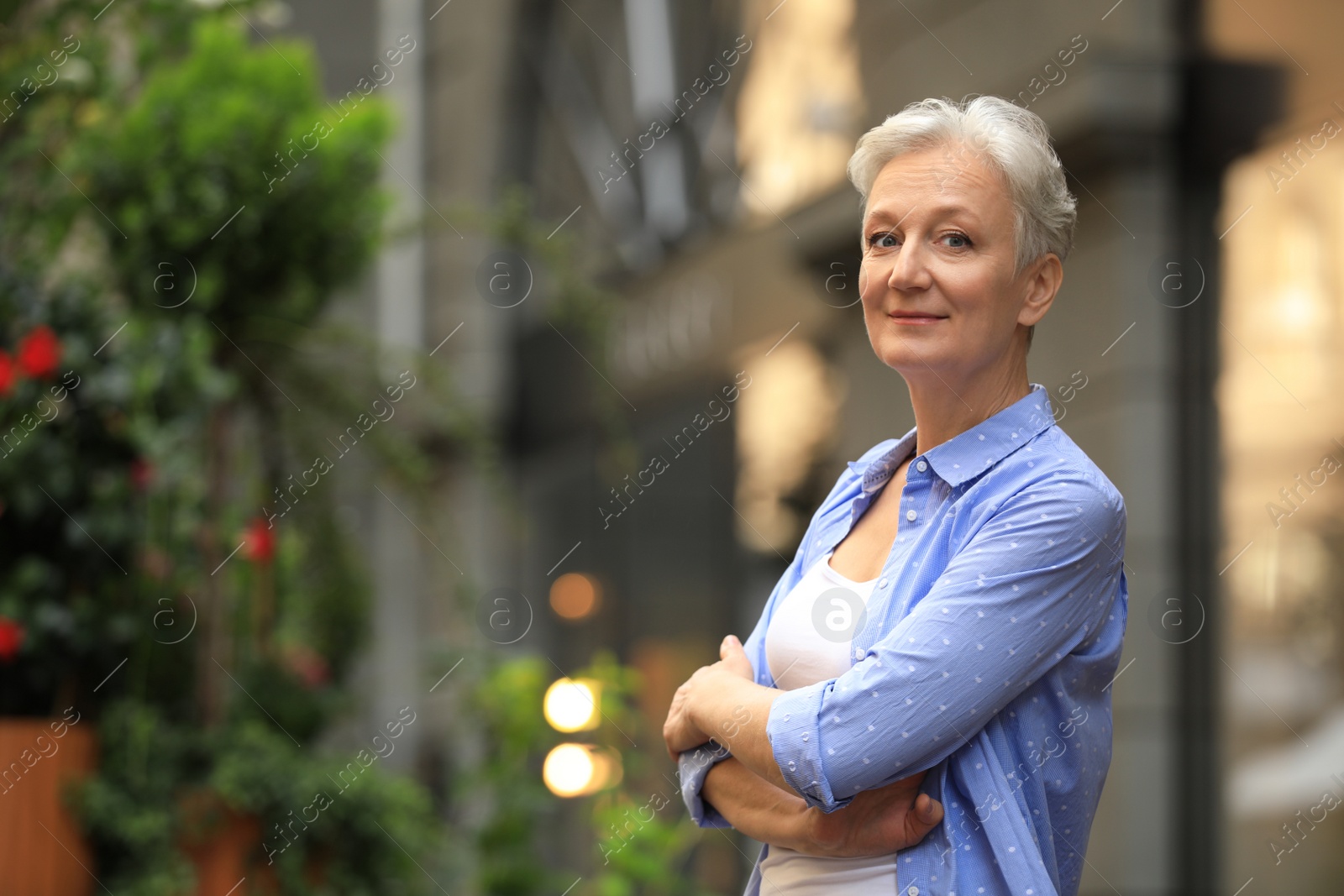 Photo of Happy mature woman on city street, space for text. Smart aging