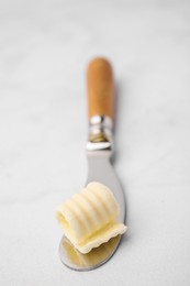 Photo of Tasty butter curl and knife on white table, closeup