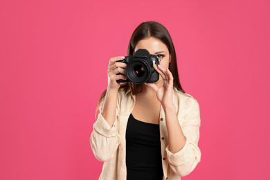 Professional photographer working on pink background in studio