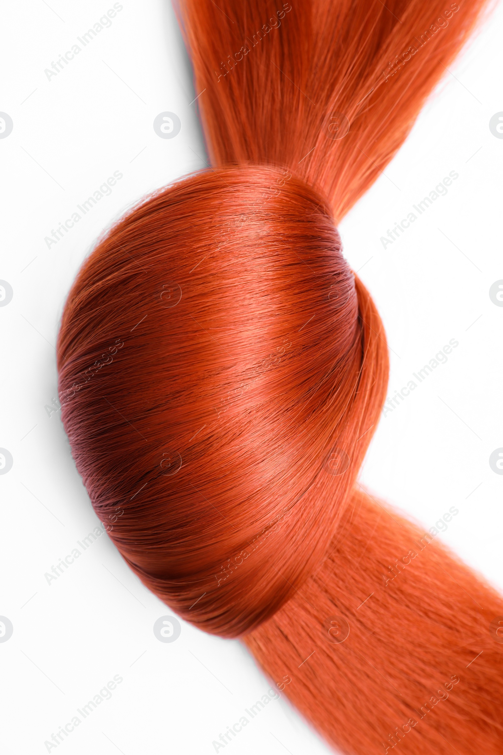 Photo of Beautiful strand of red hair tied in knot on white background, top view