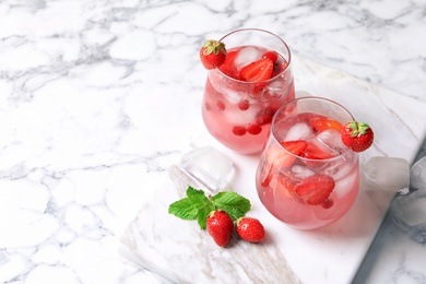 Photo of Glasses of natural lemonade with berries on table