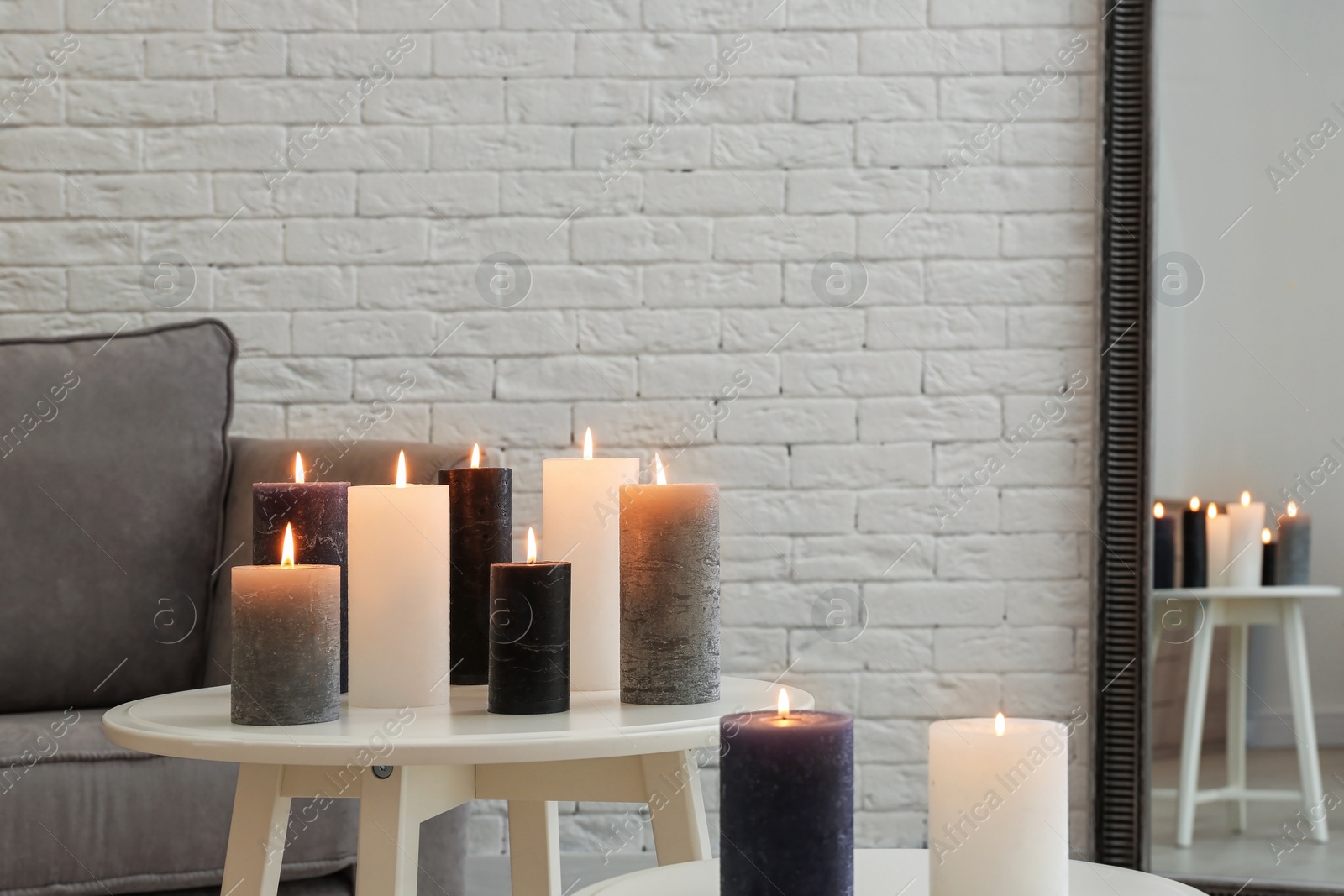 Photo of Burning candles on tables in living room