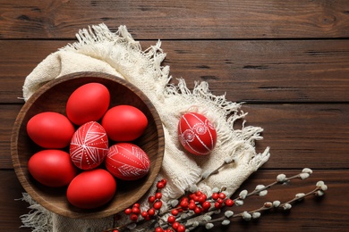 Photo of Flat lay composition with painted red Easter eggs on wooden table, space for text