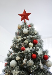 Beautiful Christmas tree with star topper indoors