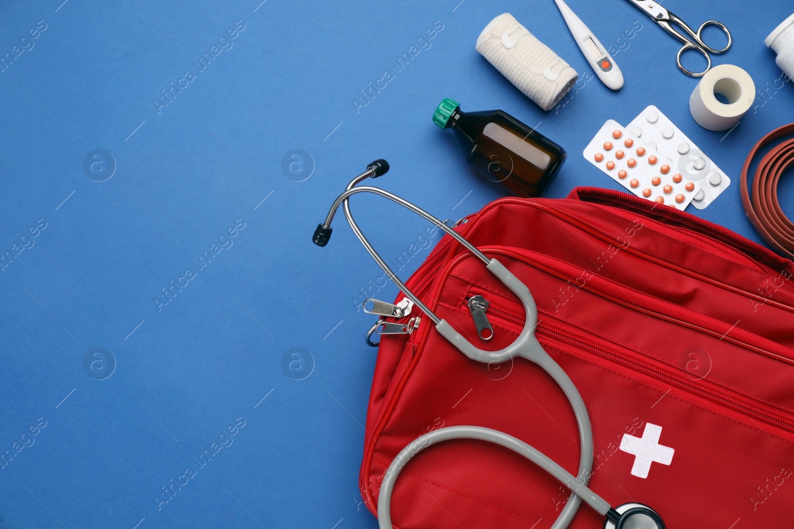 Photo of Flat lay composition with first aid kit on blue background, space for text