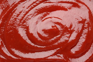 Photo of Tasty ketchup as background, top view. Tomato sauce