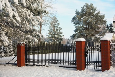 Photo of Winter landscape with beautiful snowy park behind fence in morning