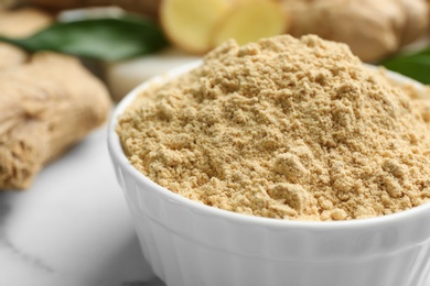 Photo of Dry ginger powder in bowl on table, closeup