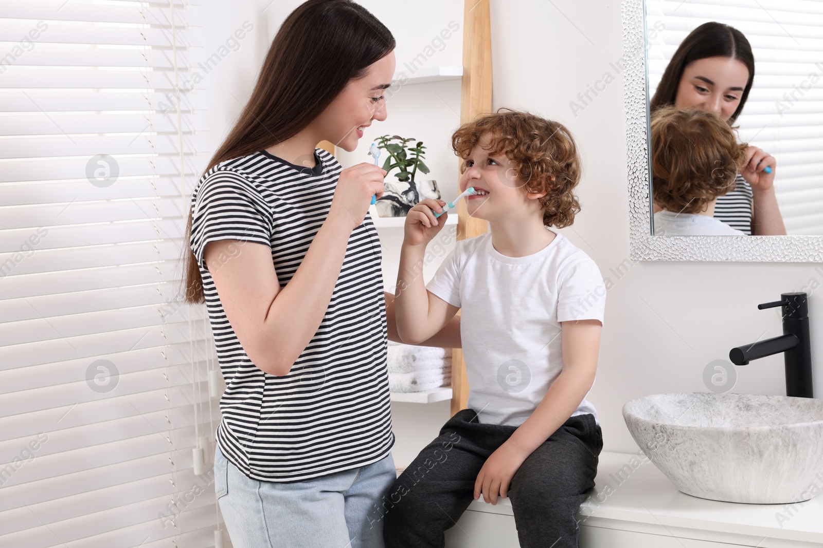 Photo of Mother and her son brushing teeth together in bathroom