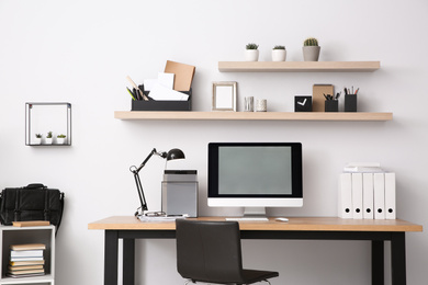 Photo of Modern computer on table in office interior. Stylish workplace