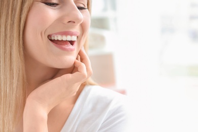 Photo of Young woman with beautiful smile indoors. Teeth whitening