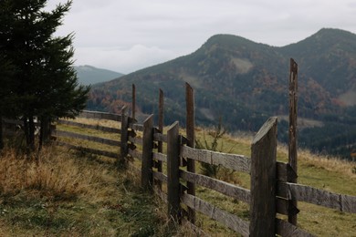 Photo of Picturesque view of mountain landscape with forest and wooden fence