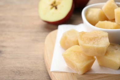 Photo of Frozen apple puree cubes and ingredient on wooden table, closeup. Space for text