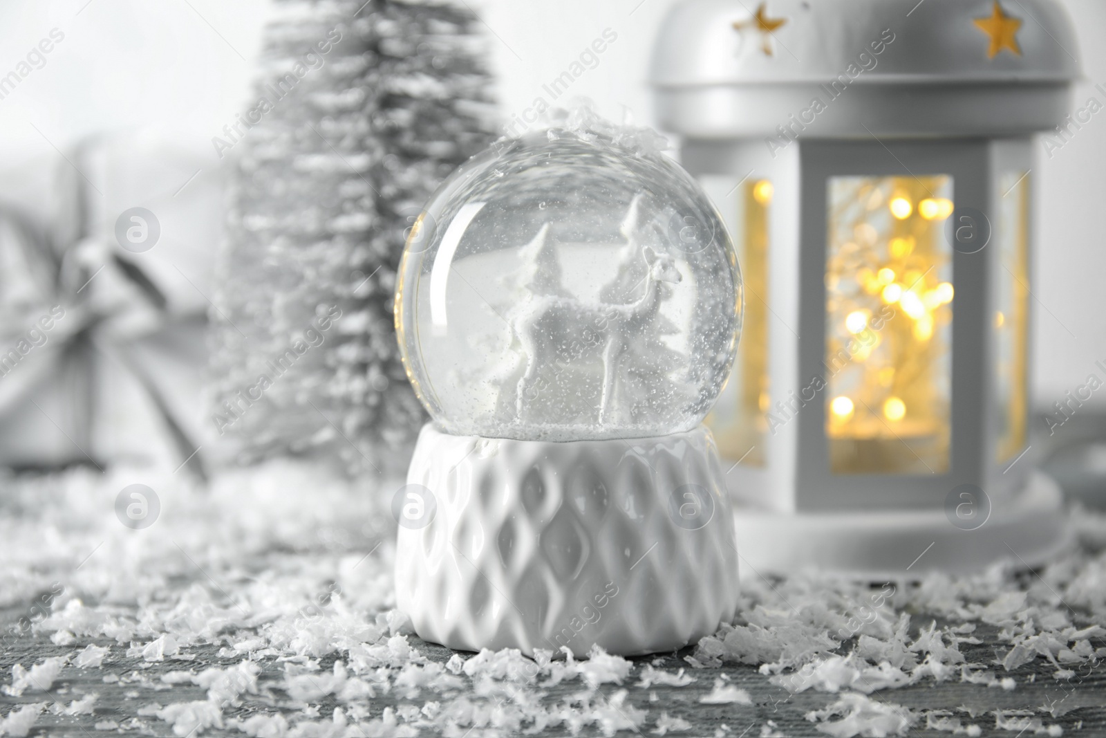 Photo of Snow globe with Christmas decorations on table