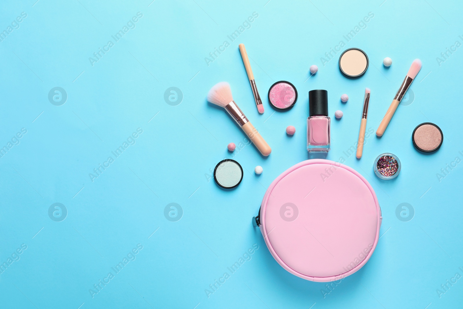 Photo of Makeup products with cosmetic bag on color background