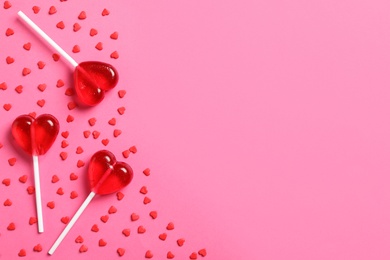 Photo of Sweet heart shaped lollipops and sprinkles on pink background, flat lay with space for text. Valentine's day celebration