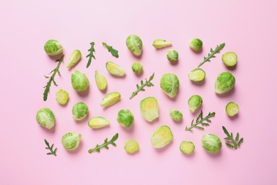 Fresh Brussels sprouts and arugula on color background, flat lay