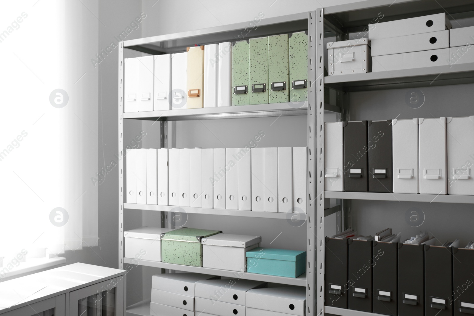 Photo of Folders with documents on shelves in archive