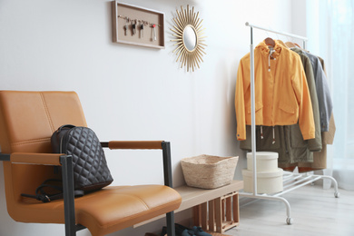 Photo of Hallway interior with stylish furniture, clothes and accessories
