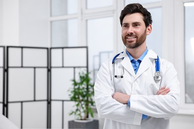 Medical consultant with stethoscope in clinic, space for text