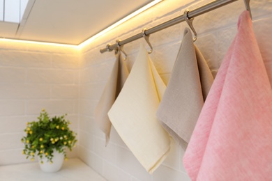 Clean kitchen towels hanging on wall indoors, closeup