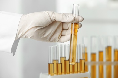 Photo of Doctor holding test tube with urine sample for hemp analysis in laboratory, closeup