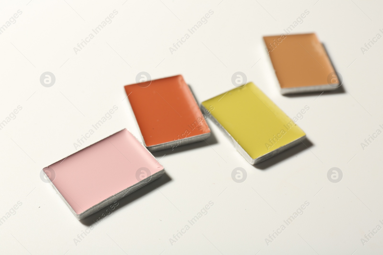Photo of Different color correcting concealers on white background