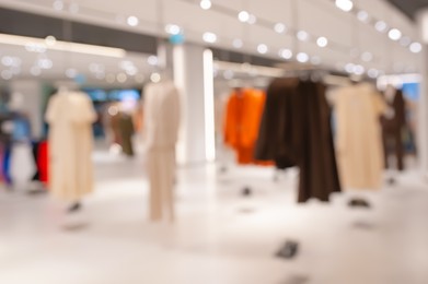 Photo of Blurred view of modern boutique interior with stylish clothes