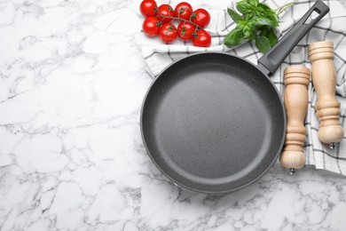 Flat lay composition with frying pan and fresh products on white marble table, space for text