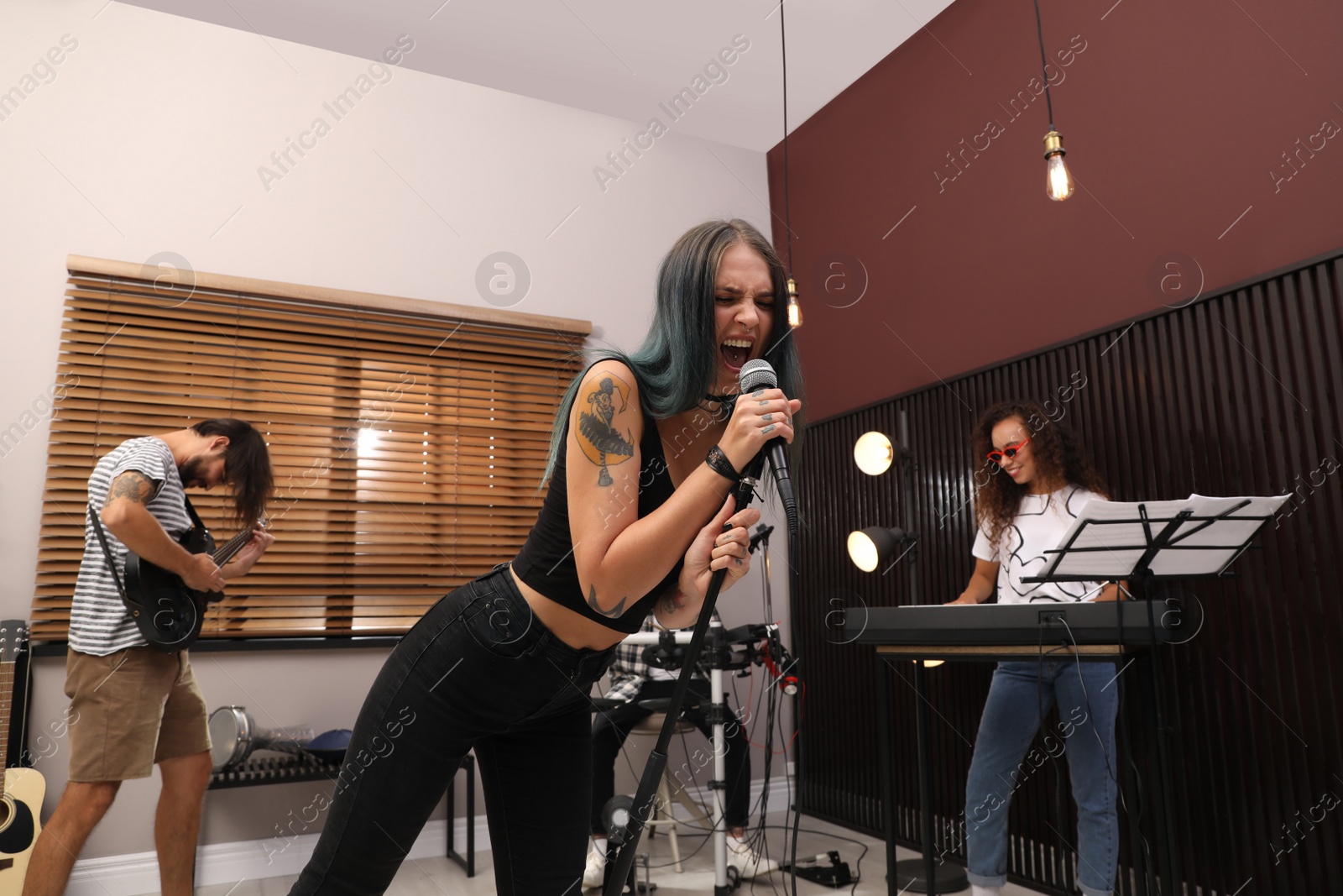 Photo of Music band performing in modern recording studio