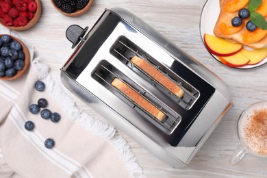 Photo of Flat lay composition with modern toaster on white wooden table