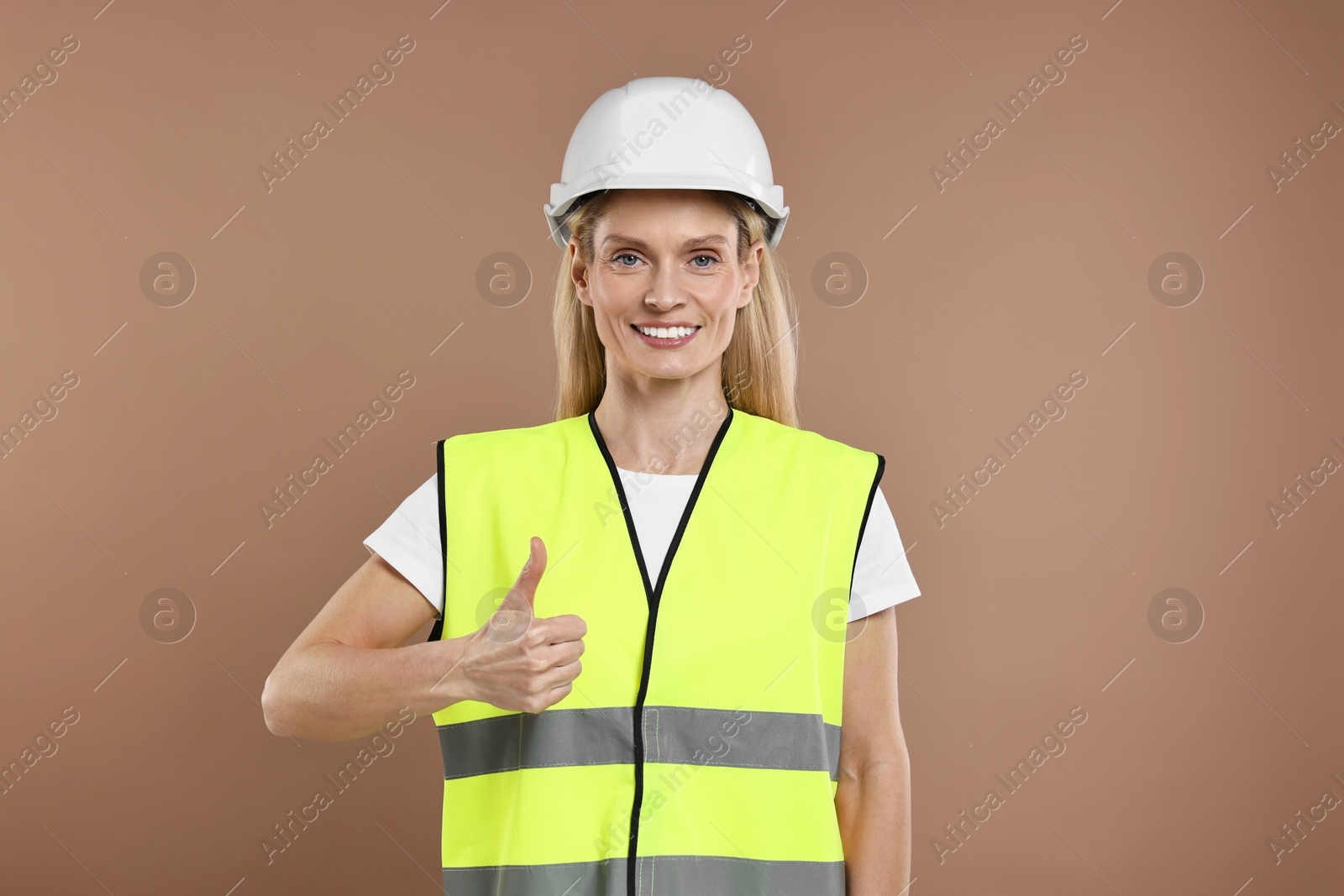 Photo of Engineer in hard hat on brown background