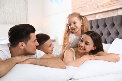 Happy young family together on large bed