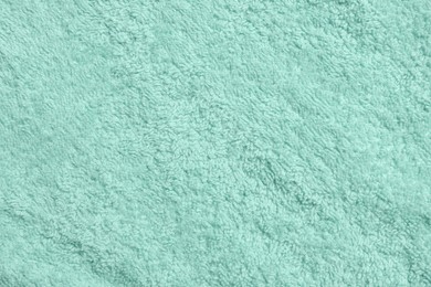 Photo of Soft light turquoise towel as background, top view