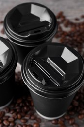 Coffee to go. Paper cups and roasted beans on table, closeup