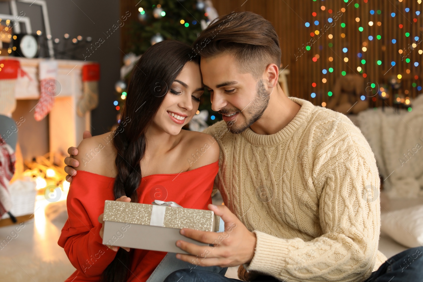 Photo of Young couple with Christmas gift box at home