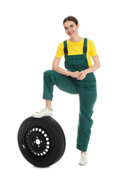 Full length portrait of professional auto mechanic with wheel on white background