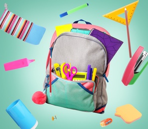 Image of Backpack surrounded by flying school stationery on pale green background