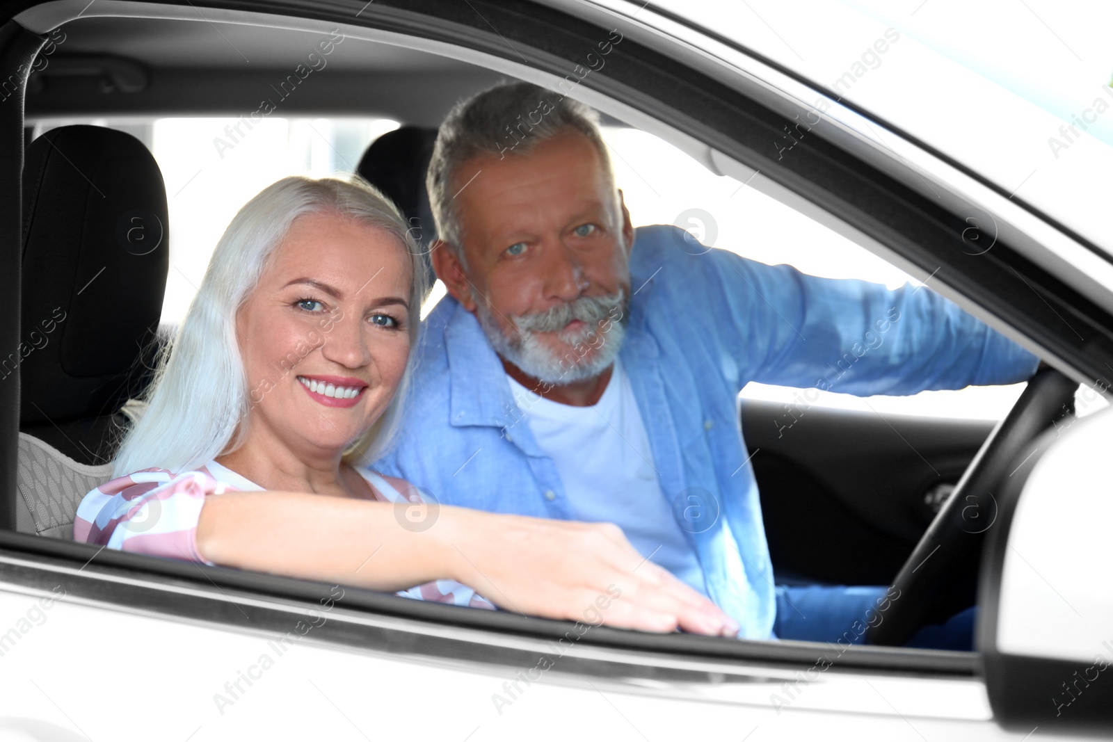 Photo of Happy senior couple travelling together in car