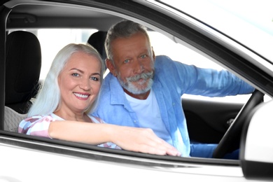 Happy senior couple travelling together in car