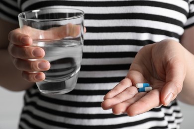 Photo of Woman with glass of water and pills, closeup