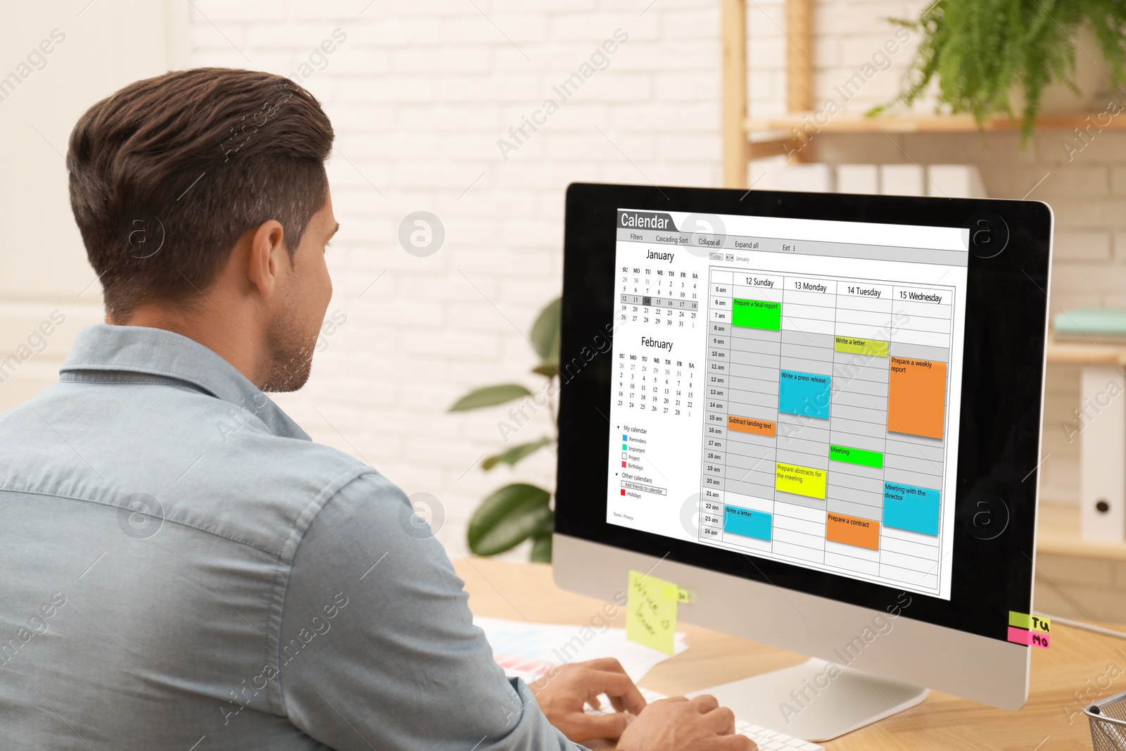 Photo of Man using calendar app on computer in office