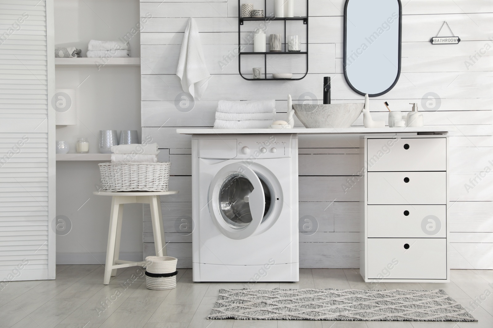 Photo of Stylish bathroom interior with modern washing machine