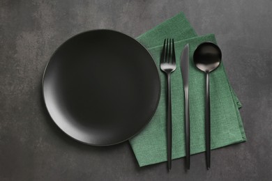 Photo of Empty plate, fork and knife on black table, flat lay